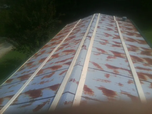 Rusted metal roof panels with new wood purlins before replacement — Storm Damage Roof Repair in Wheat Ridge by Roofing Brothers